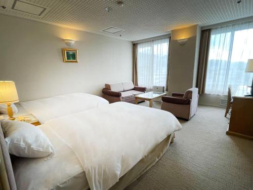 a hotel room with two beds and a living room at Shirahama Key Terrace Hotel Seamore in Shirahama