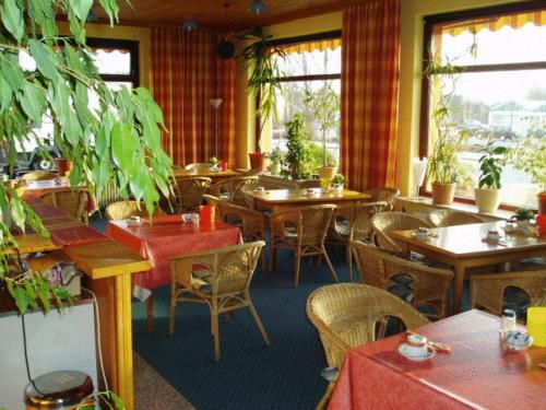 een restaurant met tafels en stoelen en planten erin bij Hotel Friedrichs in Neumünster