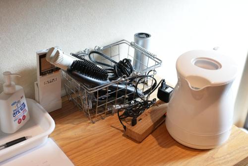 a hair dryer sitting on top of a wooden table at Nekokura Hostel in Fukuoka