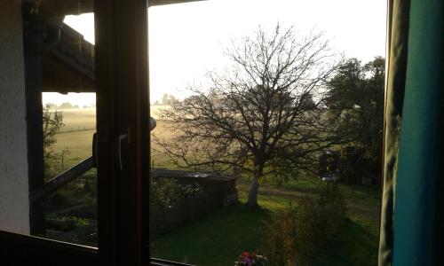 una ventana con vistas al campo desde una casa en Ferienwohnung ChiemseeZeit :-) - Familie Lechermann en Gstadt am Chiemsee