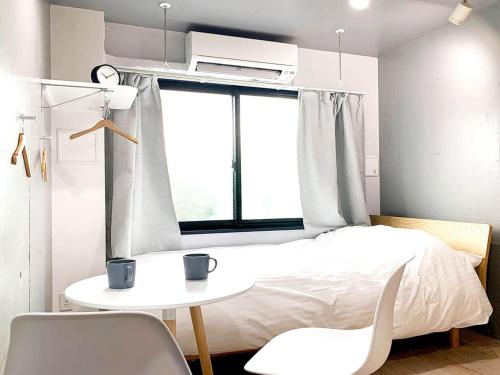 a bedroom with a bed and a table and chairs at Itos Ebisu in Tokyo