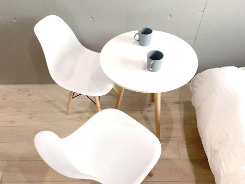 two white chairs and a table with a cup on it at Itos Ebisu in Tokyo