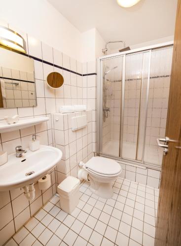 a bathroom with a toilet sink and a shower at Hotel am Schlosspark Essen in Essen