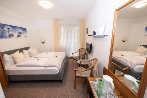 a hotel room with two beds and a mirror at Hotel am Schlosspark Essen in Essen