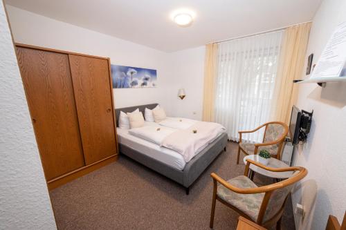 a hotel room with a bed and a chair at Hotel am Schlosspark Essen in Essen