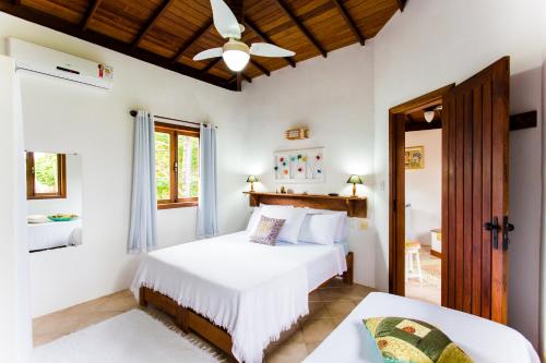 a bedroom with two beds and a ceiling fan at Pousada Recanto do Arraial in Arraial d'Ajuda
