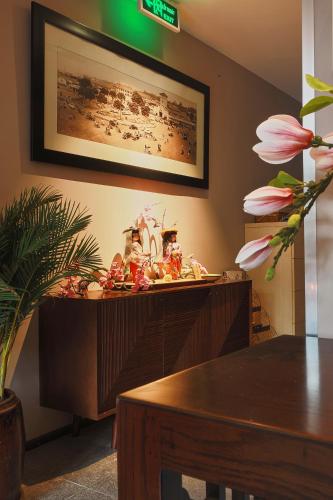 a wooden cabinet with a table and flowers on it at CHERRY BOUTIQUE HOTEL in Ho Chi Minh City