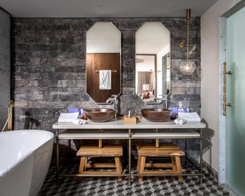 a bathroom with two sinks and two mirrors at Mizpe Hayamim by Isrotel Exclusive in Rosh Pinna
