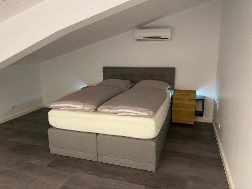 a bed sitting in a room under an attic at Loft- Ferienwohnung perfekt für Fahrradfahrer in Nortrup