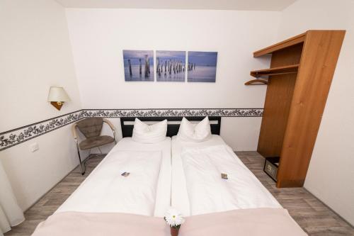 a bed in a room with white sheets at Hotel am Schlosspark Essen in Essen