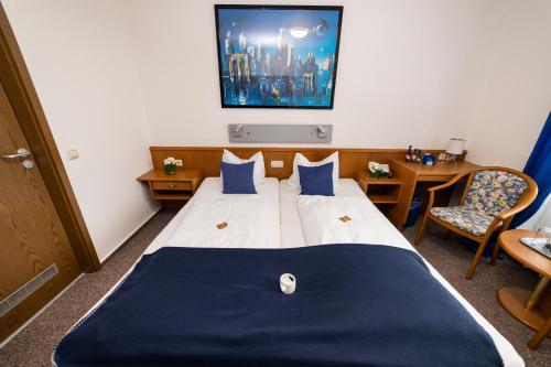 a hotel room with a bed with a blue blanket at Hotel am Schlosspark Essen in Essen