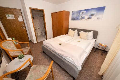 a bedroom with a large bed and a table and chairs at Hotel am Schlosspark Essen in Essen