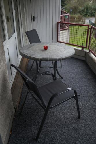 a table and a chair sitting on a balcony at Hotel am Schlosspark Essen in Essen