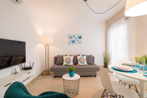 een woonkamer met een bank en een tafel bij Peña City Center Apartment in Málaga