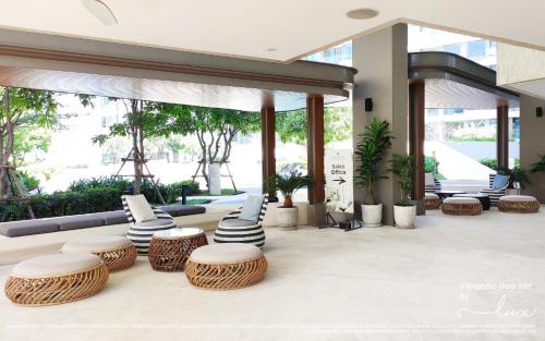 a lobby with wicker chairs and tables in a building at VERANDA HUAHIN - Residence Pool Access in Hua Hin