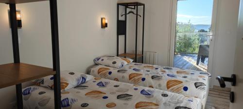 a bedroom with a bed with a comforter and a window at Les terrasse du rody, vue mer . in Guipavas