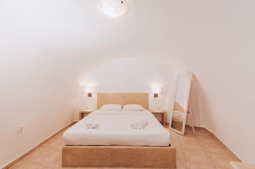 a bedroom with a bed with two towels on it at Gemini Cave in Oia