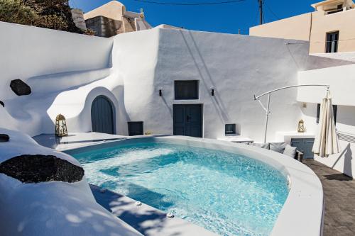 a swimming pool in the middle of a house at Gemini Cave in Oia