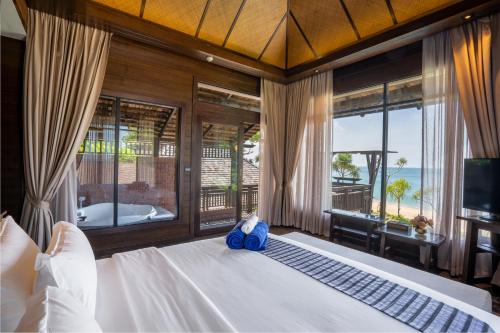 a bedroom with a bed with a view of the ocean at Nirvana Beach Resort, Koh Lanta SHA Extra Plus in Ko Lanta