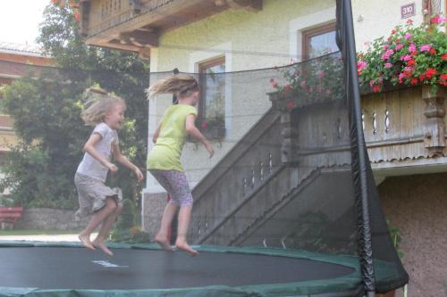 two young girls playing on a trampoline at Leitnerhof in Niederau