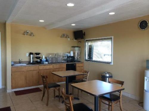 a kitchen with two tables and chairs and a counter at Americas Best Value Inn Schulenburg in Schulenburg