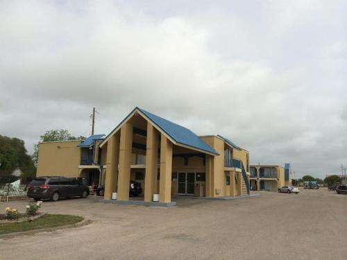 a building with cars parked in a parking lot at Americas Best Value Inn Schulenburg in Schulenburg