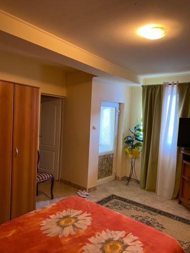 a bedroom with a bed with an orange blanket with flowers on it at house in the woods in Reşiţa