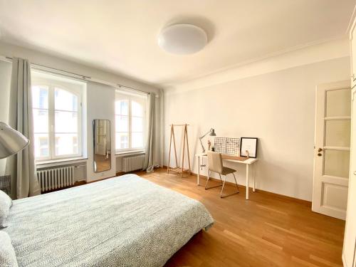 a white bedroom with a bed and a desk at Highstatic - Large and Bright 2BR in the nightlife District in Luxembourg