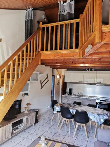 une cuisine avec un escalier en bois, une table et des chaises dans l'établissement Appart T4 72m2 à Baratier entre les Orres et Embrun à coté du lac de Serre Ponçon., à Baratier