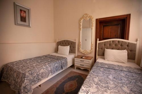 a bedroom with two beds and a mirror at Lily Town Hotel in Antalya