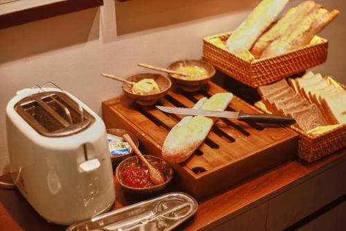 a cutting board with bread and a toaster on a counter at CHERRY BOUTIQUE HOTEL in Ho Chi Minh City