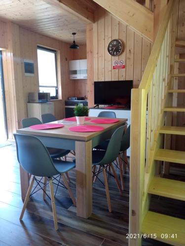 a dining room with a table and chairs and a kitchen at Domki pod Jaworem Brenna in Brenna