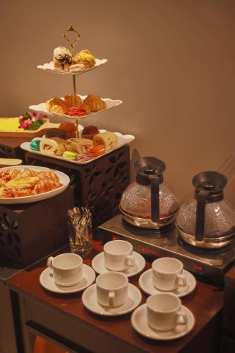 a table with cups and saucers and other food at CHERRY BOUTIQUE HOTEL in Ho Chi Minh City