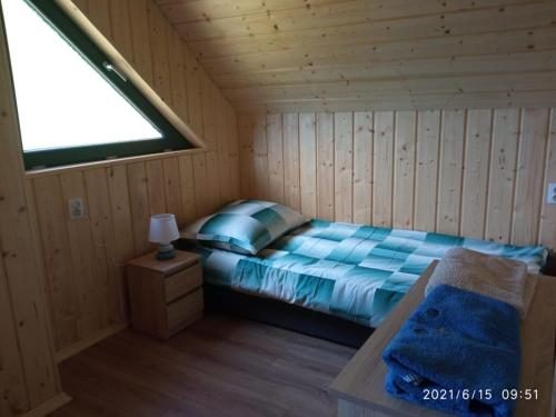 a bedroom with a bed in a wooden cabin at Domki pod Jaworem Brenna in Brenna