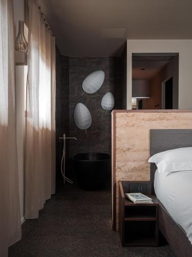 a bedroom with a bathroom with a tub and a bed at Agriturismo Terra del Sole in Albosaggia