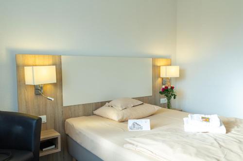 a hotel room with a bed and a chair at Hotel Kelkheimer Hof in Kelkheim