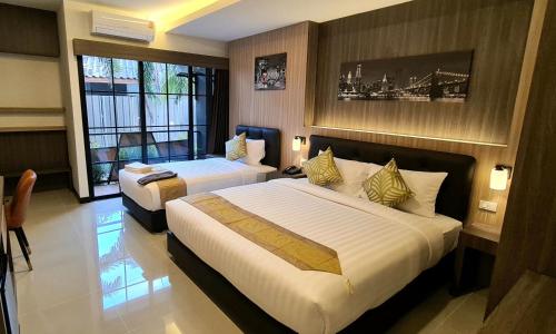a hotel room with two beds and a window at The Room Boutique Hotel in Sakon Nakhon