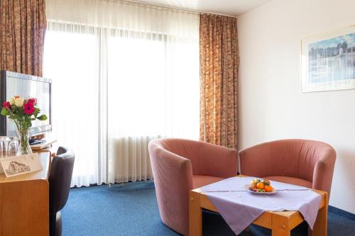 a room with a couch and a table with oranges on it at Hotel Kelkheimer Hof in Kelkheim
