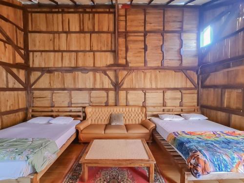 Cette chambre comprend 2 lits et une table. dans l'établissement Family Guest House Lembang RedPartner, à Lembang