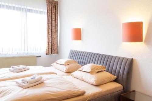 a bedroom with two beds with pillows on them at Hotel Kelkheimer Hof in Kelkheim