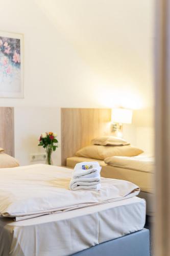 a hospital room with two beds with towels on the bed at Hotel Kelkheimer Hof in Kelkheim