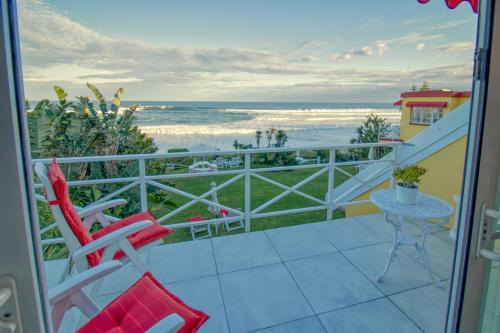 a balcony with two chairs and a table and the ocean at Haus am Strand - on the Beach in Wilderness