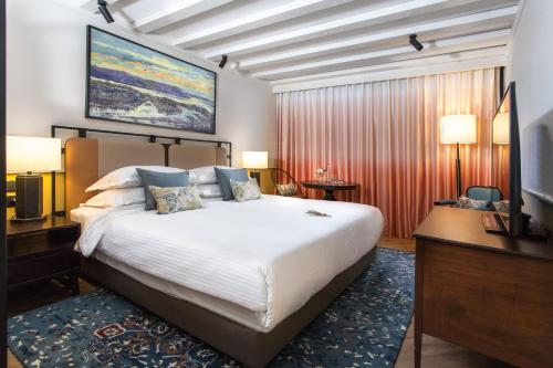 a hotel room with a large bed and a desk at Mizpe Hayamim by Isrotel Exclusive in Rosh Pinna