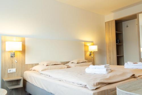 a bedroom with two beds with towels on them at Hotel Kelkheimer Hof in Kelkheim