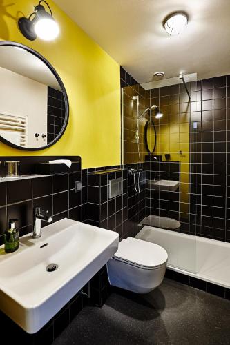 a bathroom with a sink and a toilet and a mirror at Hotel Zugbrücke Grenzau GmbH in Höhr-Grenzhausen