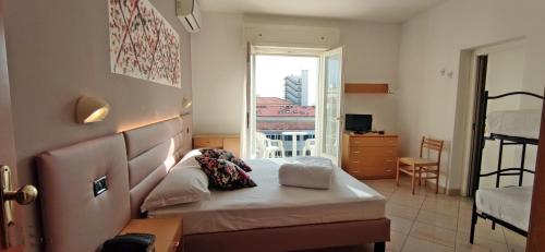 una camera con letto e vista su un balcone di Hotel Villa Platani a Riccione