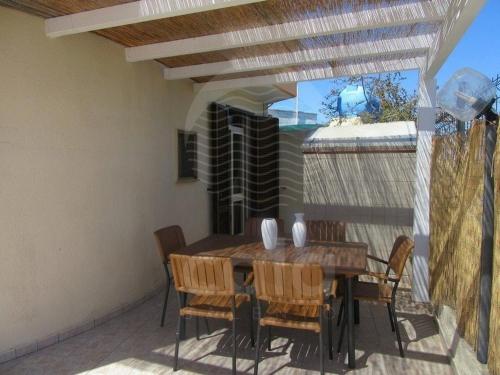 a wooden table and chairs on a patio at Villa Due Mari By Cala Salento in Torre Lapillo