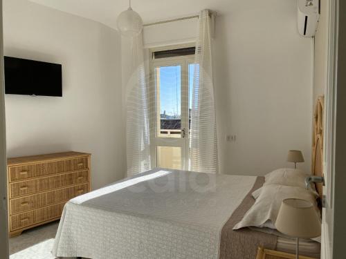 トッレ・ラピッロにあるVilla Due Mariの白いベッドルーム(ベッド1台、窓付)