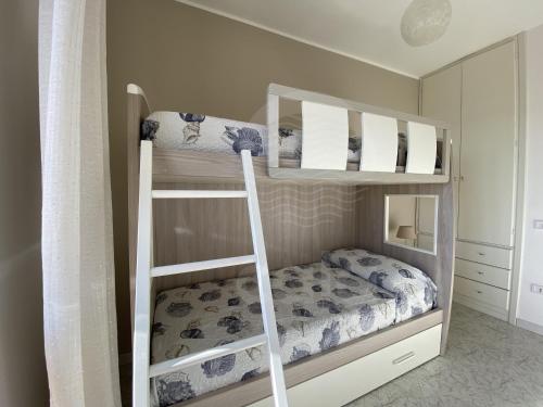 a bedroom with two bunk beds with a ladder at Villa Due Mari By Cala Salento in Torre Lapillo