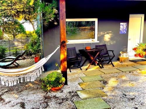 a porch with a hammock and a table and chairs at Quinta do Meco - Beach & Nature in Aldeia do Meco